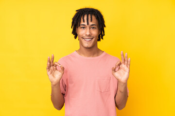 Young african american man isolated on yellow background showing an ok sign with fingers