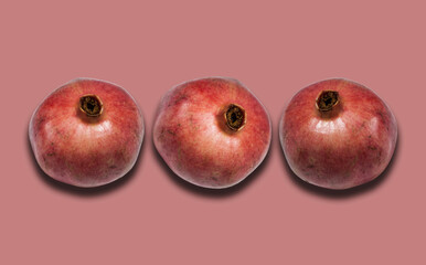 ripe red pomegranate fruit on pink background with copy space for your text, healthy vegetarian diet top view.