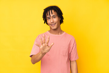 Young african american man isolated on yellow background counting five with fingers