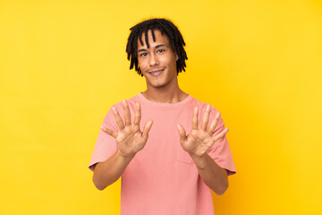 Young african american man isolated on yellow background counting ten with fingers
