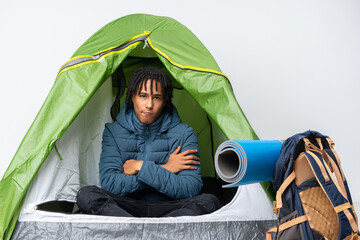 Young african american man inside a camping green tent feeling upset