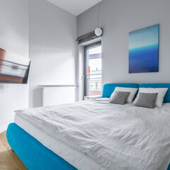 Big blue bed in small bedroom