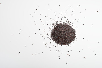 A molehill of a handful mustard seeds kept on a plain white sheet