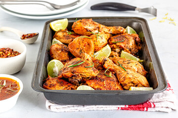 Lemon Herb Baked Chicken on a Baking Pan Garnished with Rosemary Close Up Photo