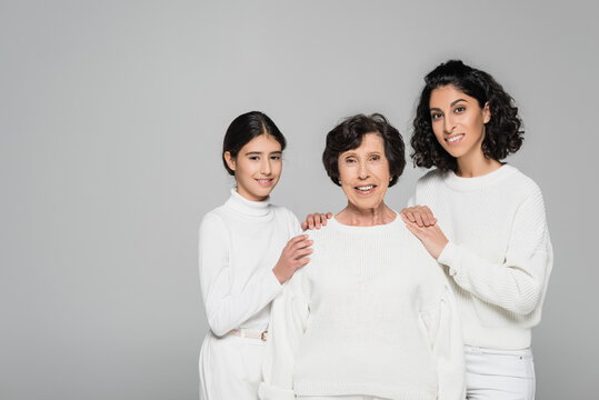 Hispanic Woman And Daughter Embracing Smiling Grandmother Isolated On Grey, Three Generations Of Women