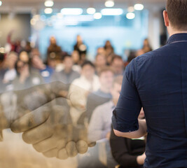 Speaker giving a talk at a corporate business conference.
Audience in hall with presenter in front of presentation screen. Corporate executive giving speech during business and entrepreneur seminar. 