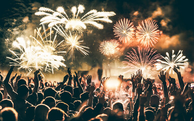 crowd with raised hands and fireworks new year banner