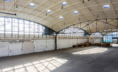 Huge industrial warehouse. Modern interior. Unique architecture. Hemispherical reinforced concrete load bearing roof. Stack wooden pallets.