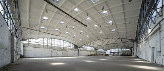 Huge industrial warehouse. White interior. Hemispherical reinforced concrete load bearing roof with windows. Modern architecture. Wooden pallets.