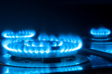 three gas burners burn with a blue flame