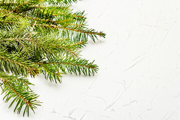 Border of Christmas tree branches on white putty background