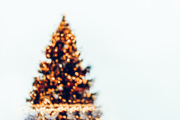 Abstract image of defocused or blurred christmas tree with bokeh as xmas lights, white background, space for text, christmas and new year card