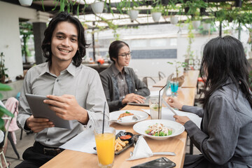Portrait cheerful of young asian business team meeting in a cafe. With friends in the background