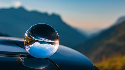 Crystal ball alpine landscape shot with reflections on a car roof at Hochgurgl, Oetztal, Tyrol, Austria