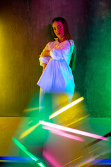 Young. Caucasian female inclusive model posing on studio background in neon light. Realness, tolerance. Her happy lifestyle is the same like of other people. Concept of wellness, diversity, beauty.
