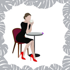 A beautiful girl with a cup in her hands sits at a table in a cafe