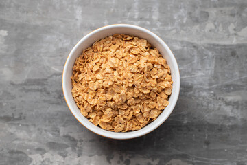 flakes wheat in the bowl on ceramic background