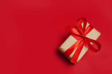 paper gift with red bow on red background. Free space for your text.