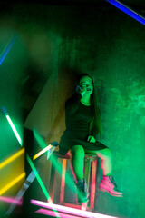 Youth. Caucasian female inclusive model posing on studio background in neon light. Realness, tolerance. Her happy lifestyle is the same like of other people. Concept of wellness, diversity, beauty.