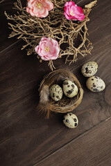 easter eggs and flowers on rustic wooden background. quail eggs