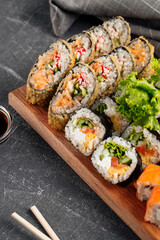 Side view on sushi roll assorted set on the wooden board with soy sauce