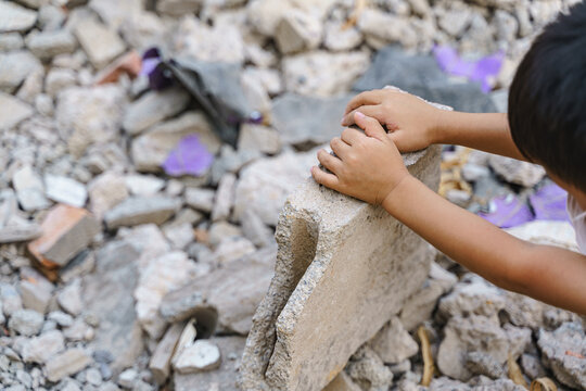Kid hands finding something in concrete debris