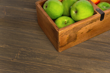 Fresh apples in a wooden box on a wooden table