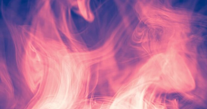 Whimsical movement of colored puffs of smoke against a dark background. Moving gas of a nebula in deep space.
