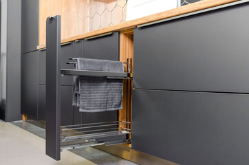 Pull-out kitchen drawer in the kitchen for towels, jars. Modern beautiful kitchen in gray, wooden...
