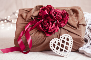 Valentine's Day gift decorated with roses and ribbons close up.