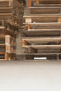 Wooden pallets piled up in a warehouse.