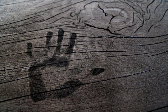 Hand print on wooden surface.