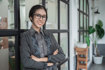 Fototapeta na wymiar Portrait cheerful of young asian business woman crossed arms in a cafe.