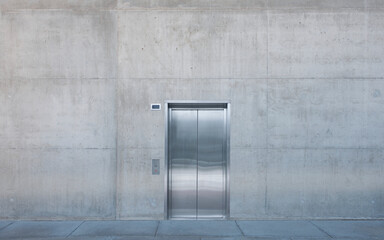 Metal elevator doors in a concrete wall.
