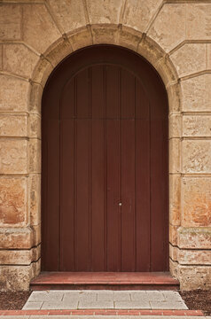 Wooden Door In Stone Arch.