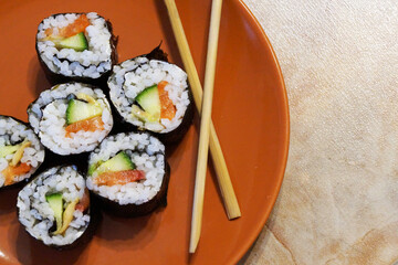 Japanese sushi and wooden sticks on a plate