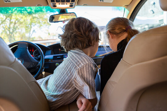 Young boy looking at camera in parked car.
