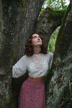 Portrait of seventeen year old girl standing in front of mossy Bigleaf maple tree