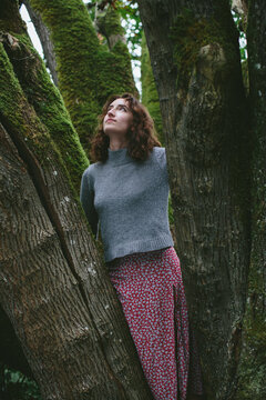 Portrait of seventeen year old girl standing in front of mossy Bigleaf maple tree