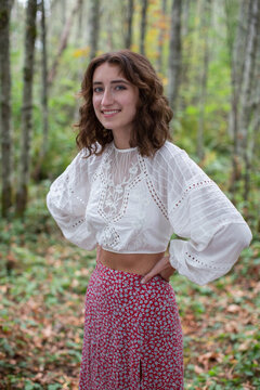 Portrait of happy seventeen year old girl standing in lush forest in Fall, Discovery Park, Seattle, Washington