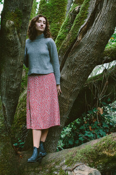 Portrait of seventeen year old girl standing in front of of moss-covered Bigleaf maple tree
