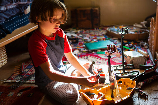 Overhead view of young boy in his room playing with his toys