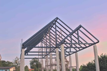 Obraz premium House structure under construction steel roof truss house pillar blue and orange background Gable roof