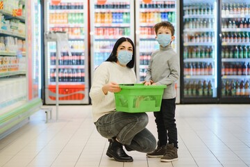 Authentic shot of mother and son wearing medical masks to protect themselves from disease while shopping for groceries together in supermarket.
