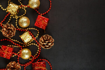 Christmas or New Years dark background with red and gold decorations for the Christmas tree with free space.