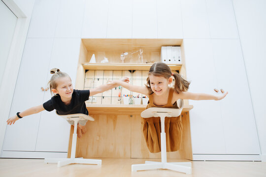 Brother and sister together play at home, making hands like wings