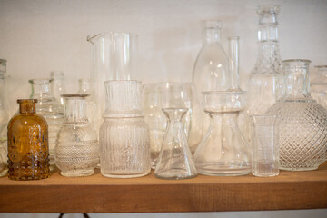 A variety of glass bottles are placed on the shelves.
