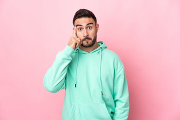 Young caucasian handsome man isolated on pink background thinking an idea