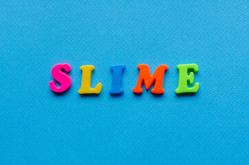 word slime on blue paper background