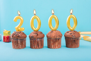 2000 Number gold candle on a cupcake against a pastel blue background two thousand year celebration